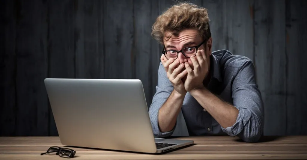 User With A Puzzled Expression Using A Laptop For Password Recovery